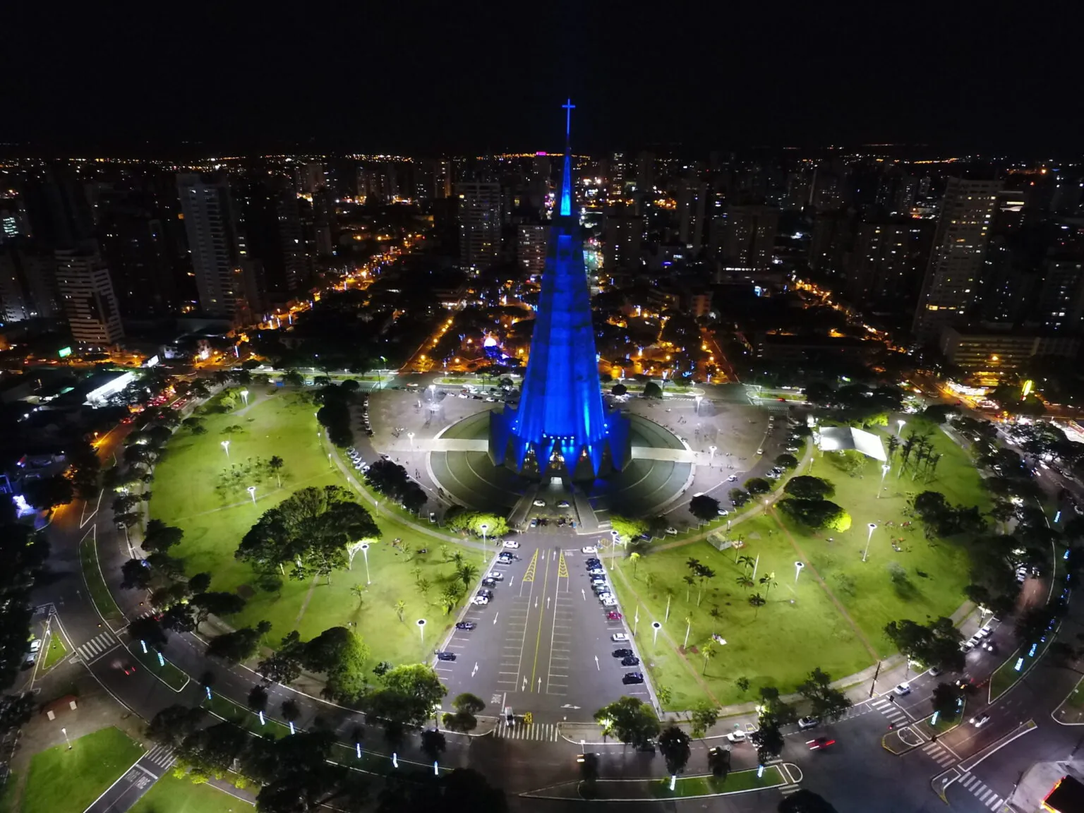 Vista aérea noturna da Catedral de Maringá iluminada e da praça ao redor